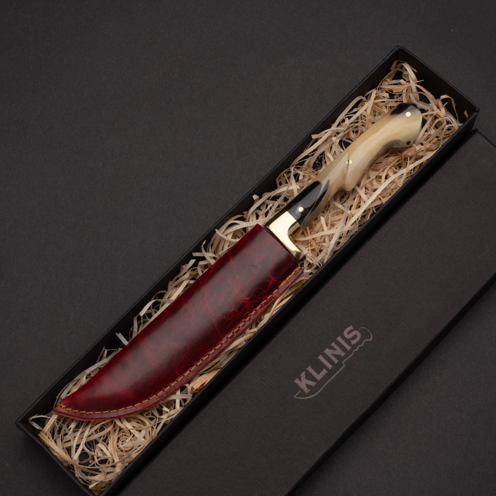 Μαχαίρι του βοσκού με λάμα από δαμασκηνό ατσάλι μπρούτζινο χειροφυλακτήρα και λαβή από κέρατο κριού σε κόκκινη δερμάτινη θήκη μέσα σε χάρτινο κουτί